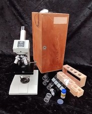 Boxed Griffin microscope with 4 lenses, specimen jars and fluid plus slides.