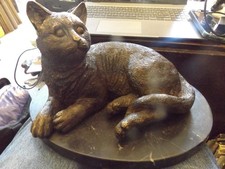 Bronze sitting cat  on black