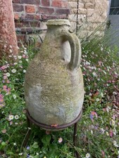 antique old medium size olive jar with metal stand for garden deco