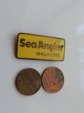 A YELLOW ENAMEL BADGE, SEA ANGLER MAGAZINE.