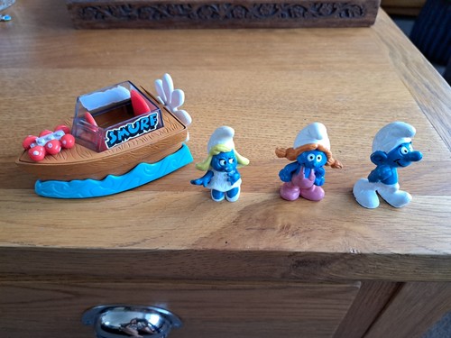Three smurf figures and boat - smurf,