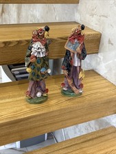 two clown figurines. They are collectible ceramic sculptures