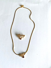 A pretty gold coloured necklace and matching brooch with a red stone in each