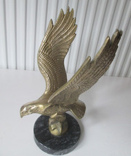 Vintage solid brass eagle statue in flying/landing position on marble base.