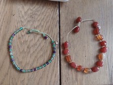 Lola Rose Bracelets, one is purple and green, the other is amber