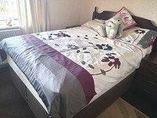 Double divan bed with mahogany coloured head board