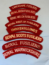 A COLLECTION EIGHT CLOTH FUSILIERS SHOULDER TITLES .