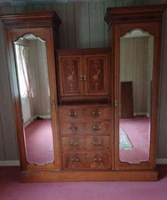 Antique mahogany double wardrobe with mirrors and a central drawer unit.
