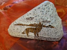 hand-carved soapstone plaque depicting a howling wolf