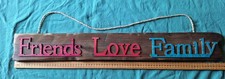 Decorative wooden sign with words the "Friends Love Family" attached
