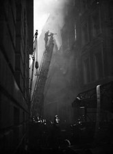 A fireman mounts his ladder to