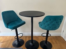 A small high round table with two height adjustable chairs