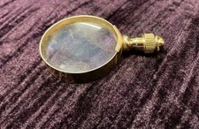 small retro gold coloured magnifying glass