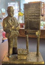 Brass figurine  bookmaker and betting board from a horse racing event.