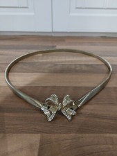 gold coloured expensive stretch belt with beautiful broach fastening to front