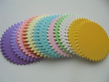 18 X ASSORTED PALER COLOURED CARD DIE CUT  SPIKED CIRCLES.