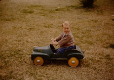 BOY POSING IN PEDDLE CAR