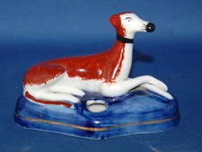 An antique style porcelain lying down greyhound dog figure pen holder