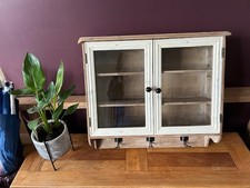 Distressed vintage look glass fronted wooden wall mounted cabinet.  Assembled.