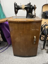 Antique Singer sewing machine in wooden cabinet