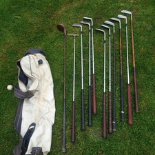 Antique vintage golf clubs.  9 irons and a putter and wood.