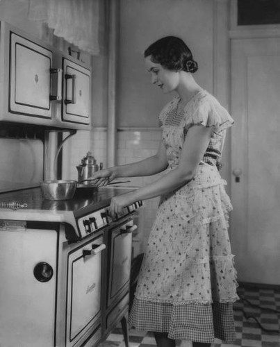 Woman turning the cooker - the,