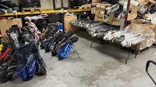 lot of golf clubs and bags