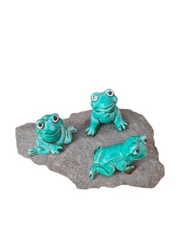 Miniature frogs sitting a - on,