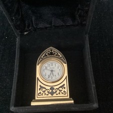 Very unusual shaped black and golden coloured fronted mantle clock with box 