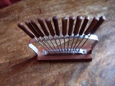 Twelve escargot, cocktail or pickle forks with teak handles & a teak based rack