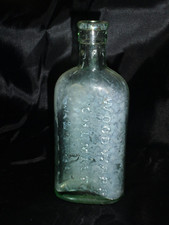 Antique Green Oval Glass Bottle in fair condition with Woodward Chemist London