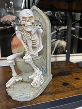 Skeleton sitting on the toilet