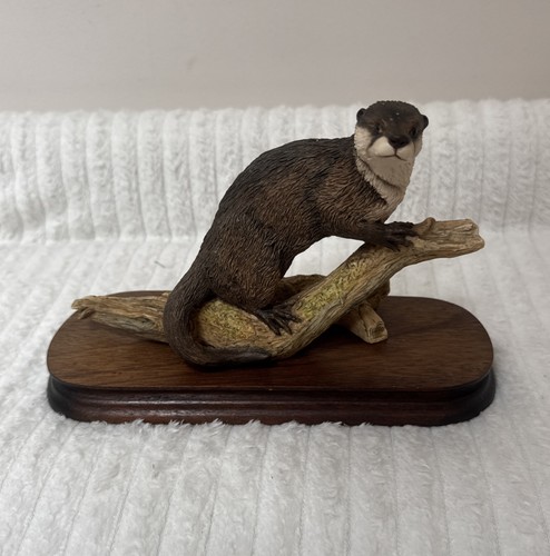 Border fine arts otter - on, log