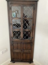 FREESTANDING VINTAGE OAK CORNER DISPLAY CABINET WITH LEADED GLAZED UPPER DOOR.