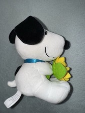 Snoopy plush holding bunch of daffodils blue collar  