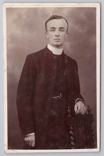 Young Edwardian priest in studio portrait, cassock & collar