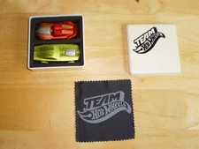 TWO VERY RARE 2012 TEAM HOTWHEELS CARS IN WHITE PLASTIC BOX WITH SOFT CLOTH