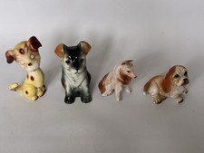 Four China Figurine Dogs.