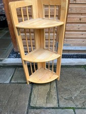 A three shelf wooden folding corner display unit.