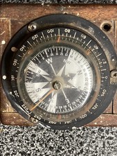 Vintage small nautical compass attached to a wood base.