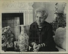 1974 Press Photo Mrs Wade Lupe sits on couch in front of a fireplace for photo