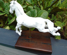 White metal horse statue on hardwood plinth