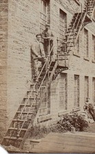 VINTAGE PHOTOGRAPH postcard:   WORKMEN ON A FIRE ESCAPE STAIRS mill factory