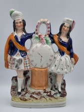 Staffordshire antique Scottish couple leaning on a clock
