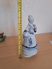 vintage porcelain music box figurine of a woman in a white and blue dress 1950s