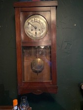 A 1930's oak cased clock with key and working pendulum 26x65cm