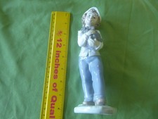 A 'LLADRO'  FIGURINE OF A BOY CARRYiNG  A DOG