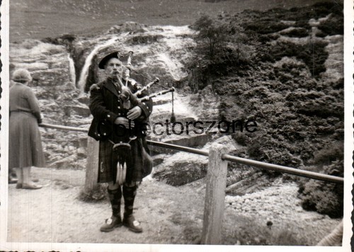 Scottish piper near - piper, waterfall