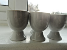 Five plain white egg cups