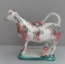 An early sponge ware decorated cow creamer with milk maid. C.1830.